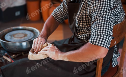 Preview: Close up photo of ceramist packages his fresh product in the paper