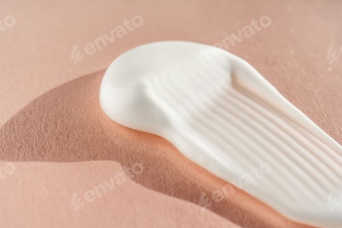 Preview: The texture of the white cream on a pink background.