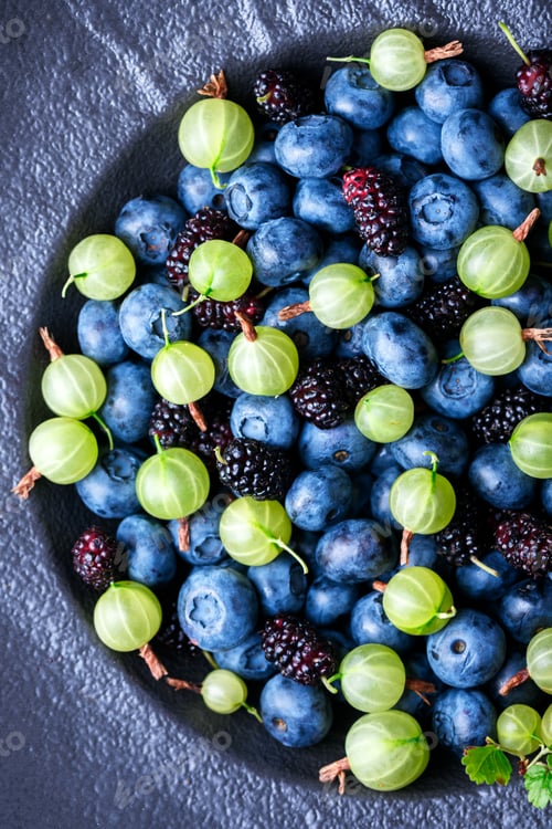 Preview: Top view on black plate filled with fresh mixed berries,