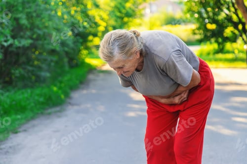 Preview: grandmother has a stomach ache on the road. Selective focus.