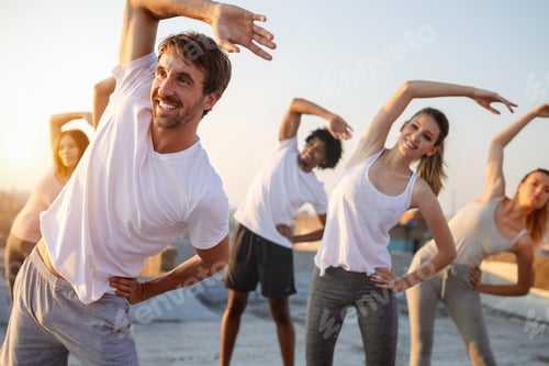 Preview: Group of athletic young people, friends in sportswear doing exercises. Sport outdoors