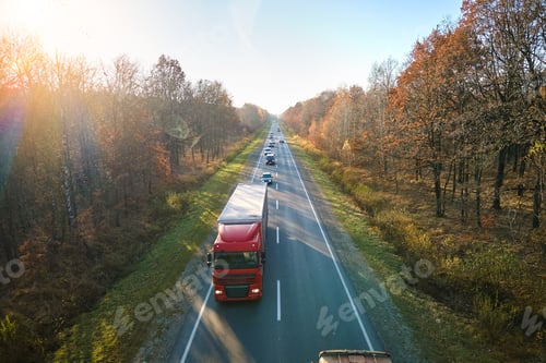 Preview: Aerial view of semi-truck with cargo trailer driving on highway hauling goods in evening. Delivery