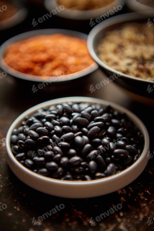 Preview: Raw black beans in ceramic bowl. Selective focus