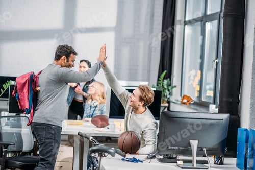 Preview: happy men greeting each other in modern office