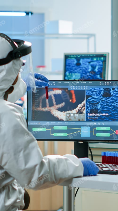 Preview: Scientists in protection suits analysing test tubes with blood sample