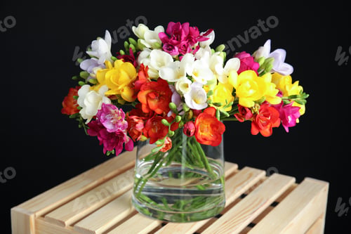 Preview: Bouquet of spring freesia flowers in vase on dark background