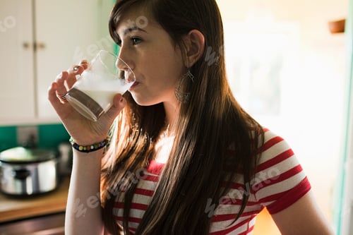 Preview: Teenage girl drinking glass of milk