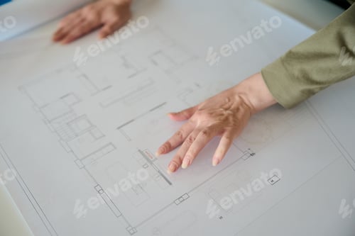 Preview: Architect hands pointing at house blueprint plan
