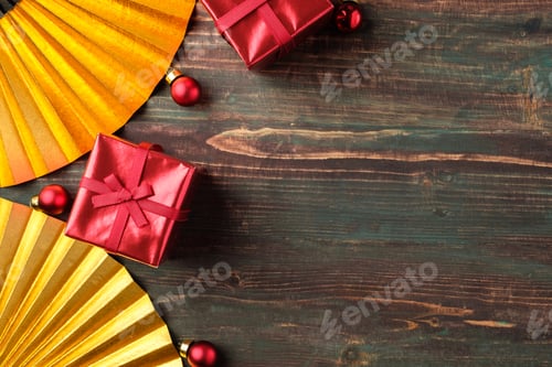 Preview: Christmas red gift box and golden fan decoration on table wood background