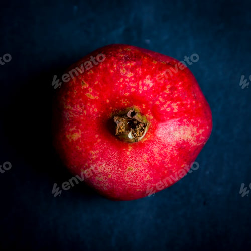 Preview: Fresh red pomegranate over dark background, studio shot