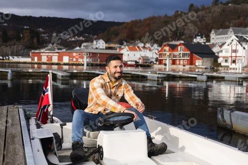 Preview: smiling man driving in a small boat in a port Norway