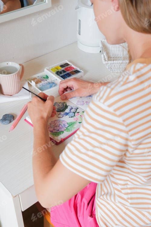 Preview: woman drawing using watercolor in hotel room on vacation