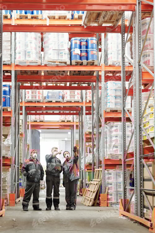 Preview: Group of warehouse workers in gloves, respirators and workwear discussing goods