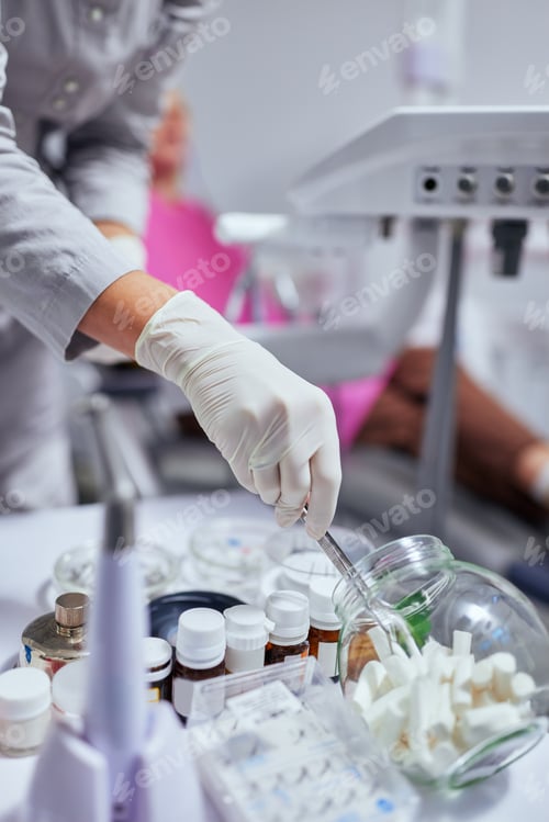 Preview: Dentist taking tampon while repairing client teeth