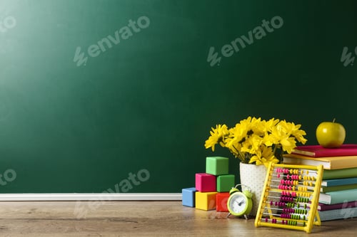 Preview: Vase of flowers, books and toys on wooden table near green chalkboard, space for text. Teacher's day