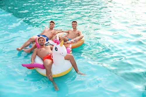 Preview: Happy young friends relaxing in swimming pool