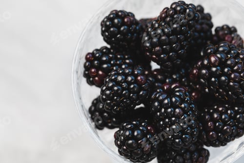 Preview: Fresh blackberries in a patterned glass bowl on gray background