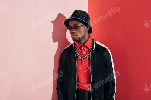 Preview: pensive stylish african american man wearing bijouterie and looking away in studio