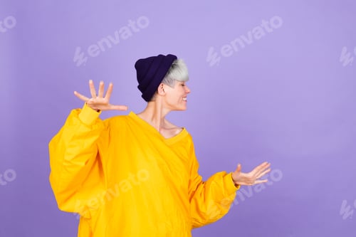 Preview: Stylish european woman on purple background happy positive dancing moving