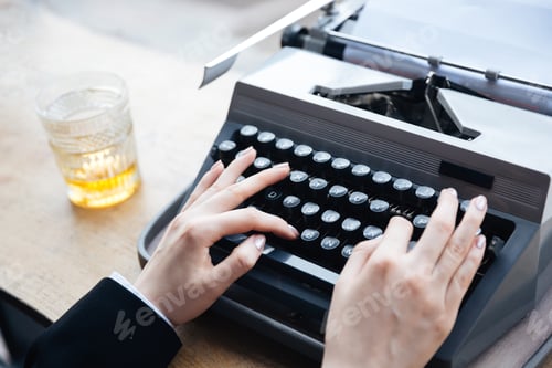 Preview: Woman's hands writing on old typewriter