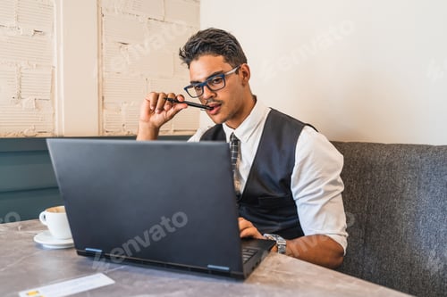 Preview: Focused Young Man Working on Laptop Indoors