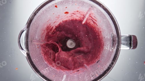 Preview: Tasty red berries smoothie mixing in blender close up top view. Sweet milkshake