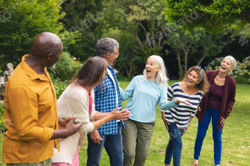 Preview: Happy multiracial senior male and female friends having fun in backyard