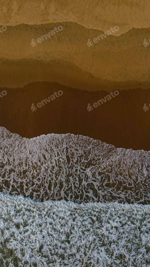Preview: Beautiful view of a beach and sea with foamy waves during sunrise