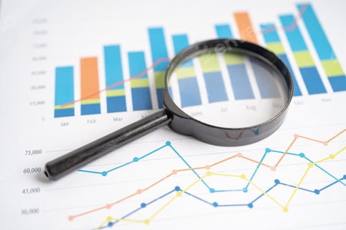Preview: Magnifying glass on charts graphs paper.