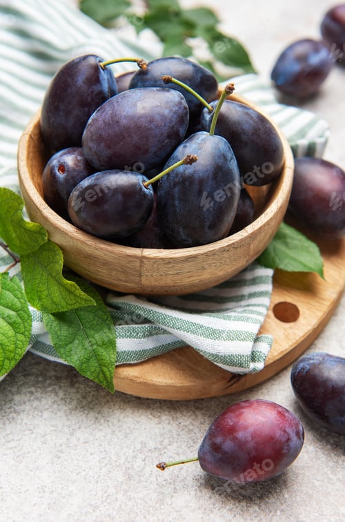 Preview: Fresh ripe plums filling a wooden bowl