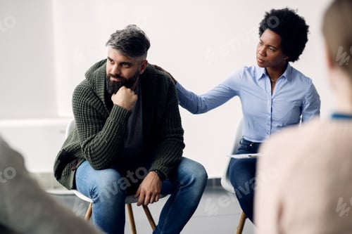 Preview: Mid adult man attending group therapy session.