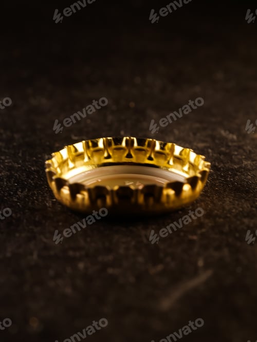 Preview: Vertical shot of gold bottle cap on a concrete surface