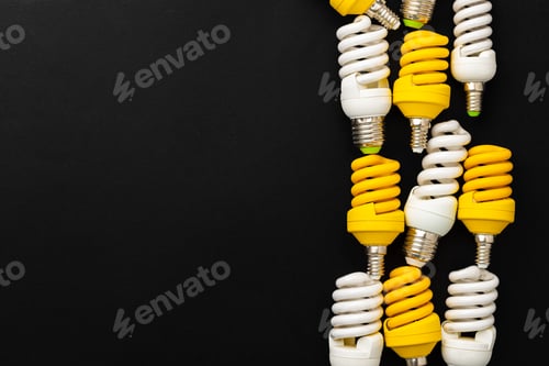 Preview: White and yellow light bulbs on black background