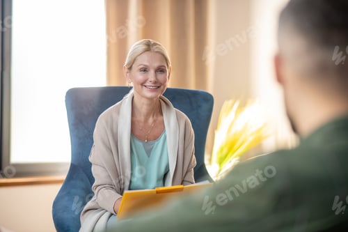 Preview: Beautiful psychoanalyst smiling while talking to client