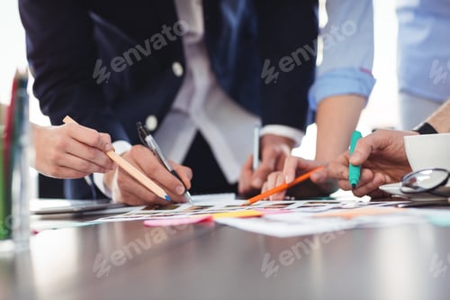 Preview: Photo editors discussing about documents on table