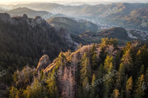 Preview: Sunrise view of a spring mountain and a small town between the slopes