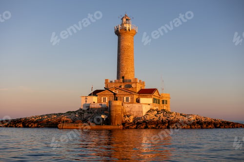 Preview: Lighthouse atop a large rock formation at sunset in Croatia