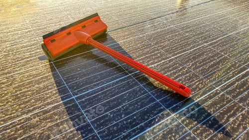 Preview: Closeup of a squeegee on a dirty solar panel under the sunlight during the sunset