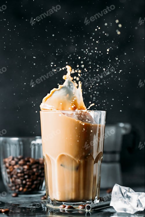 Preview: Splash of iced coffee in tall glass and coffee beans.