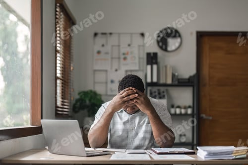 Preview: Tired depressed african businessman frustrated by business failure bankruptcy looking at laptop