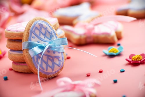 Preview: Easter baking background of frosted cookies in shape of egg on pink background