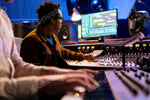 Preview: African american audio expert records artist playing piano in studio