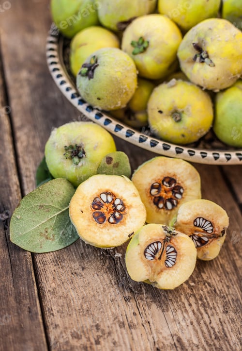 Preview: Quince harvest. Fruits in a bowl on a wooden background. Quince in a cut. Quince fruit leaf.