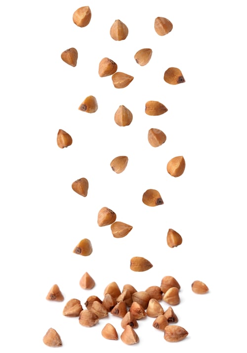 Preview: Raw buckwheat grains falling on white background