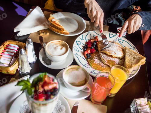 Preview: Cropped image of woman having pancake with coffee at table