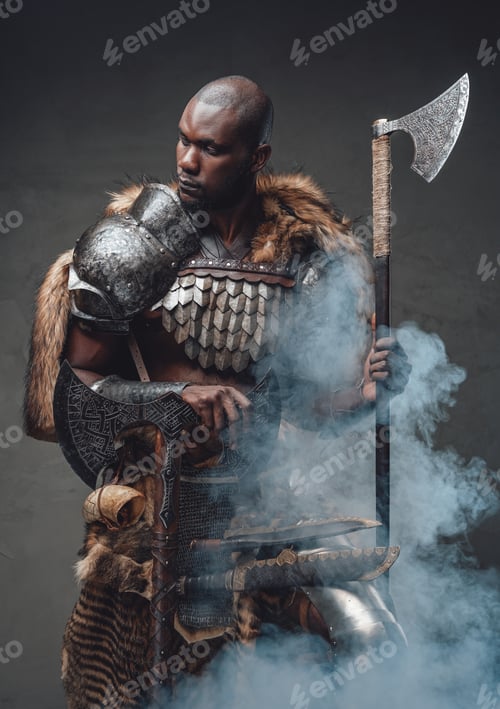 Preview: Tribal authentic soldier with axes in foggy background looks away