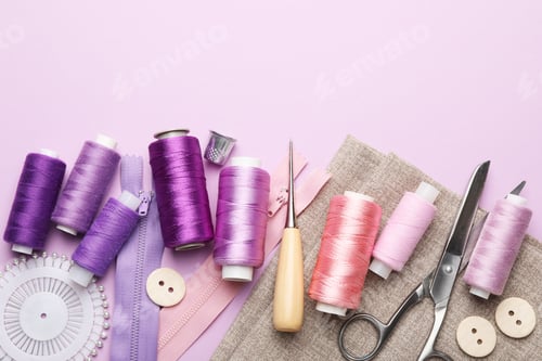 Preview: Different sewing supplies on lilac background, flat lay. Space for text