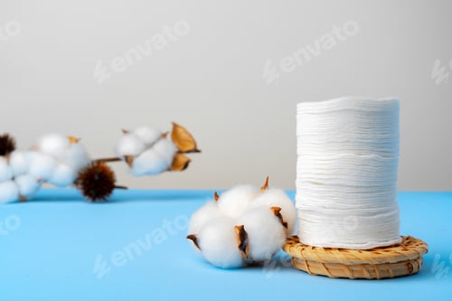 Preview: Cotton discs stack on blue paper background