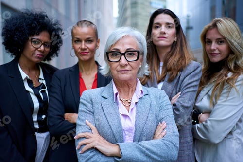 Preview: Portrait empowered women business in suits looking confident at camera with arms crossed outdoor.