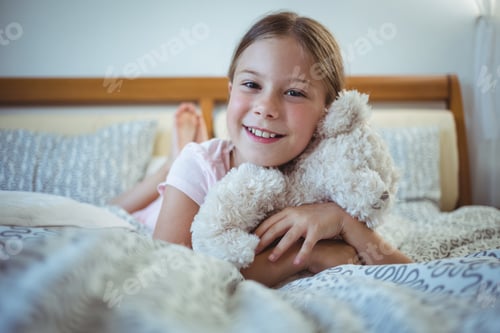 Preview: Portrait Of Happy Girl Lying With A Teddy Bear At Home